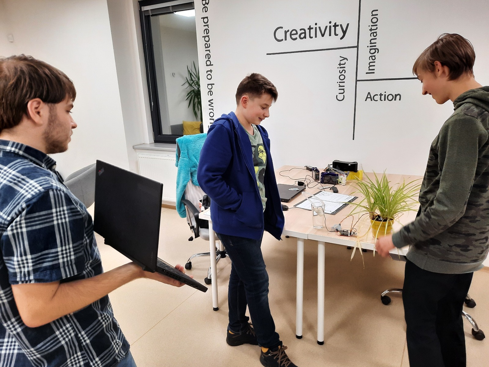 Lektor vysvětluje dětem principy programování na monitoru počítače